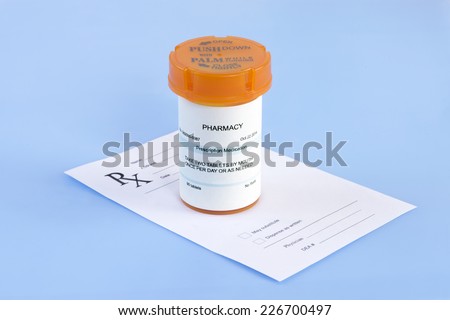 Prescription bottle and prescription on blue background.