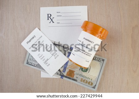 Prescription bottle, receipt and blank prescription on desktop.