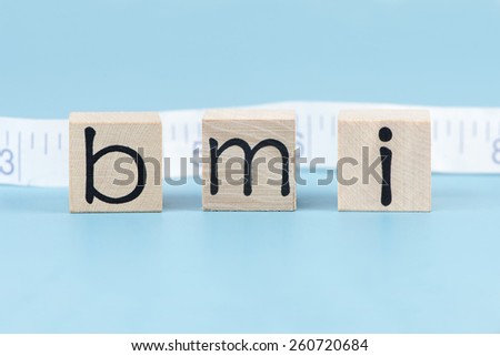 BMI body mass index letter blocks with tape measure.