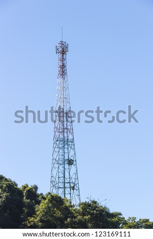 Multi purpose telecommunications tower over blue sky having antennas for tv, radio, cellular phones, microwave data links on the mountain