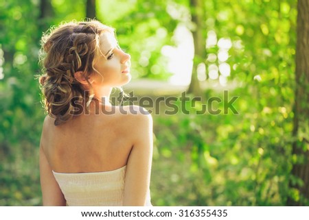 Young woman standing in the forest, back light with sunset