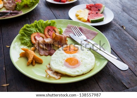 Fried egg with bacon and sausage, traditional english breakfast food