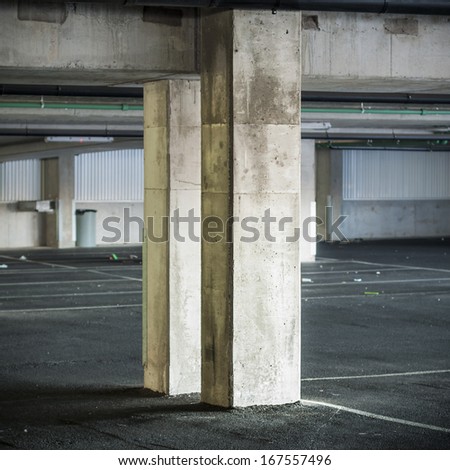 Empty parking garage interior with two concrete columns.