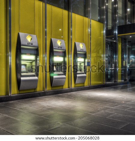 Melbourne, Australia - February 19, 2012: A row of three Commonwealth Bank automatic teller machines in the CBD at night. The Commonwealth Bank is the largest of the \