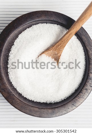 Cooking salt in a wooden bowl with small wooden serving spoon.