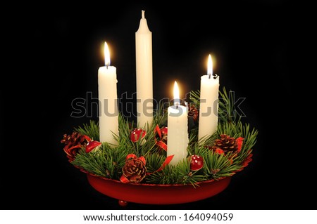 White candles in a red advent candle holder