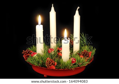 White candles in a red advent candle holder