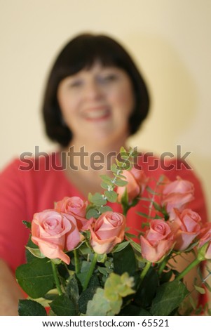 woman offering bouquet. shallow DOF, focus on flowers, woman is out of focus.