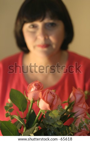woman offering bouquet. shallow DOF, focus on flowers, woman is out of focus.
