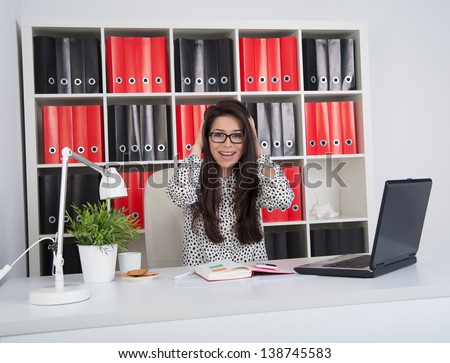 happy business woman in office holding his head