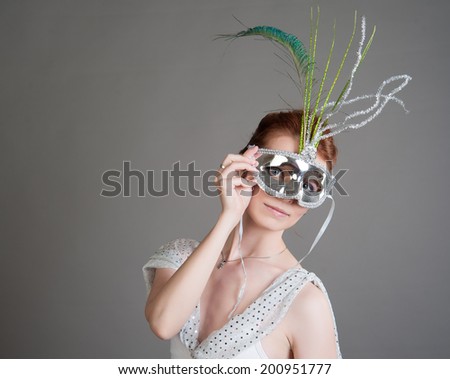 young dancer in the white suit in a mask on a grey background