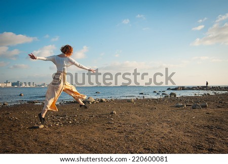 young woman jumping on the Gulf coast in the summer