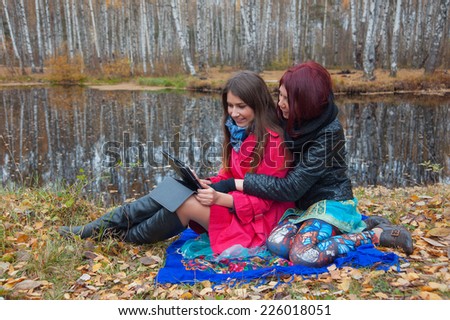 friends using laptop in the autumn park
