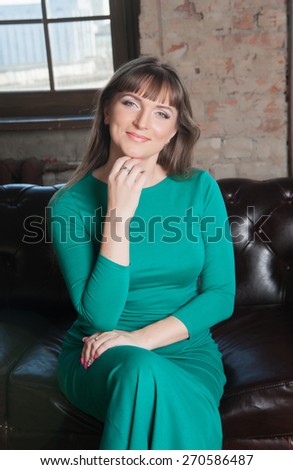 woman with long hair in green dress in the chair