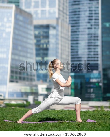 young beautiful woman doing yoga on the urban landscape