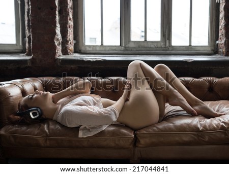 half-naked woman lying down listening to music on headphones