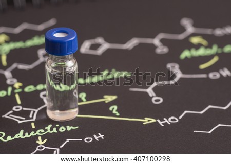 Close-up blue cap sample vial on paper with chemical formula