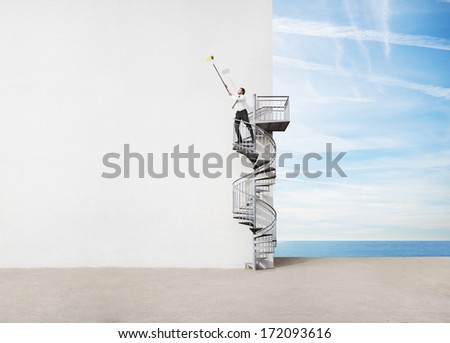 Businessman standing on spiral staircase and drawing on a wall