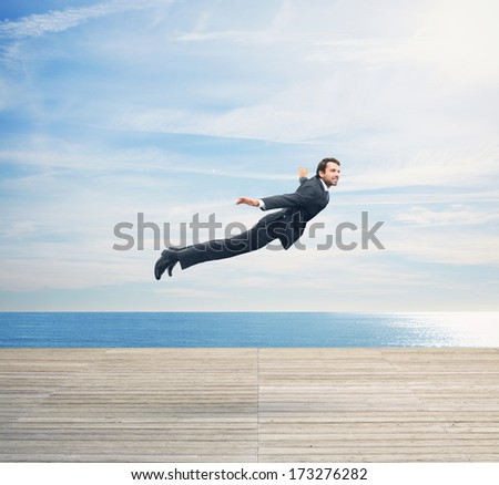 Man in suit flying over boardwalk