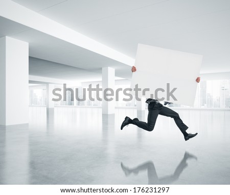 Businessman running with blank poster in his hands