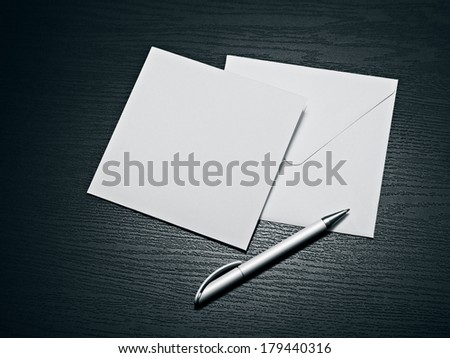 White envelope letter and white pen on black table