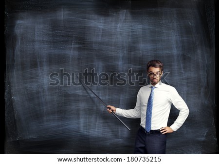 Man with pointer in his hand on black board background