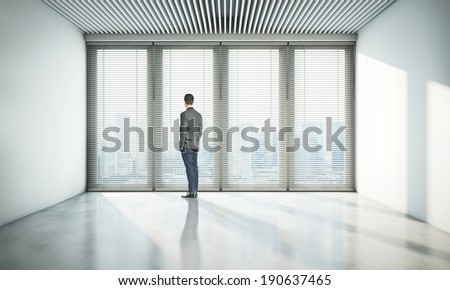 Man looking at city through window