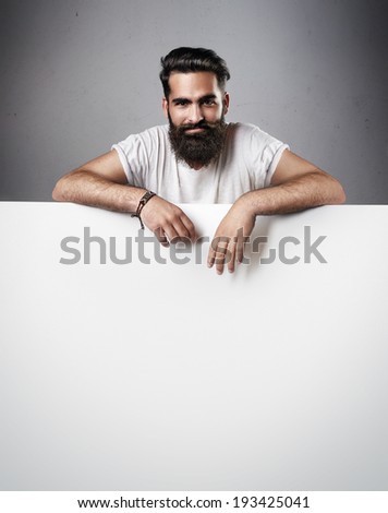 Portrait of handsome man with beard. Man holding blank poster.