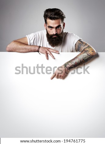 Handsome bearded man holding blank poster Handsome bearded man holding blank poster