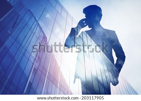 Double exposure of city and businessman on the phone
