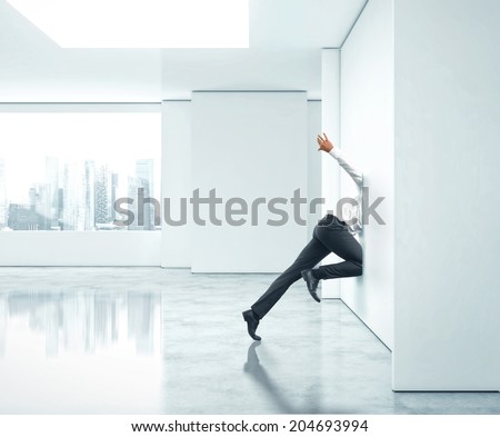 Businessman getting stuck into office wall
