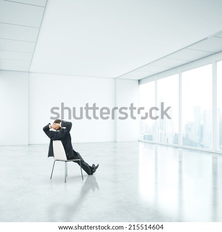 Businessman sitting in office and looking through window