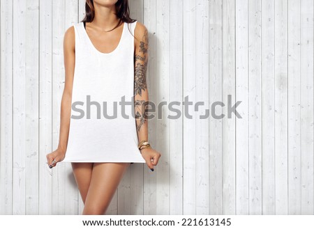 Woman wearing blank sleeveless t-shirt. Wood wall background.