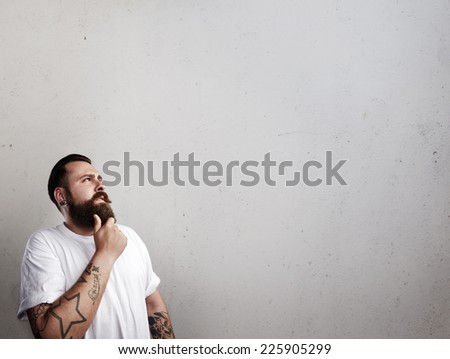 Portrait of a tattooed bearded man thinking