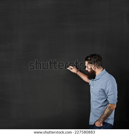 bearded hipster draws on a chalkboard