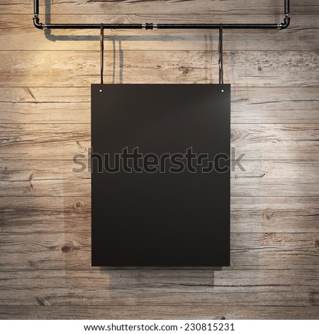 Black poster hanging on leather belt on wood background