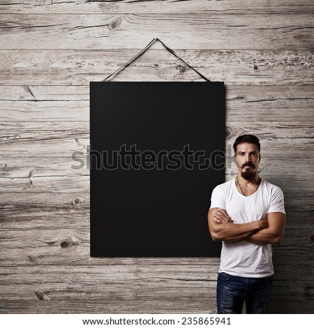 Bearded guy and black poster on a wall