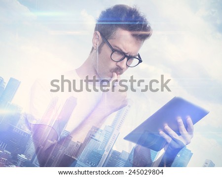 Double exposure of city and young man with tablet