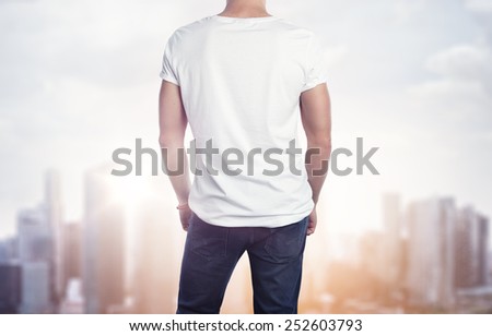Man in white t-shirt on blurred city background