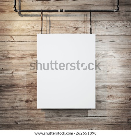 White poster hanging on leather belt on wood background