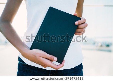 Black book in hands