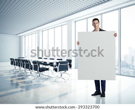 Businessman holding blank canvas at contemporary office