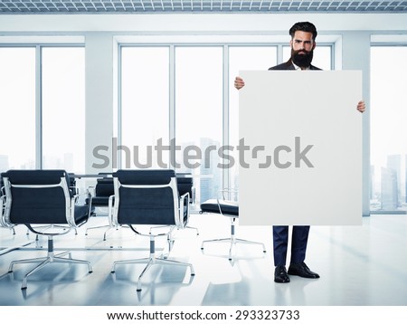Bearded businessman with white canvas at contemporary office