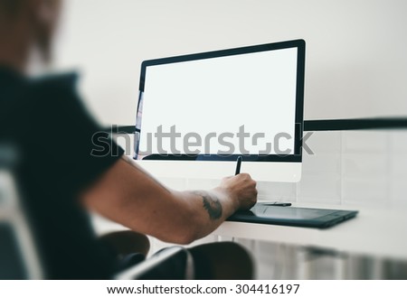 Man at workspace with generic design computer on the table.
