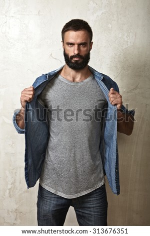 Portrait of a brutal bearded guy wearing grey t-shirt