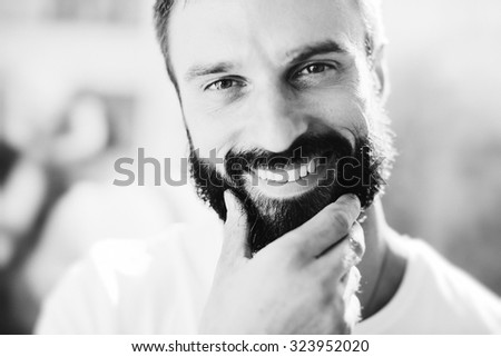 BW portrait of a bearded man wearing white tshirt and smiling