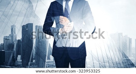 Double exposure of young business man in the skyscraper on background