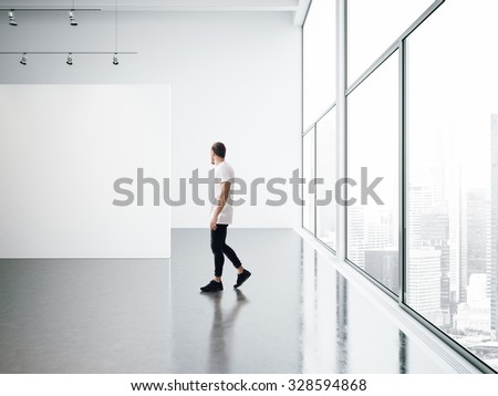 Empty gallery interior and walking young man