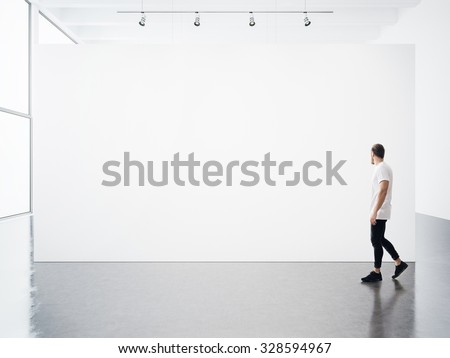 Empty interior with white, blank, canvas and young man.