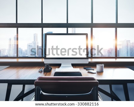 Photo of modern workspace with panoramic windows.  City at sunrise in the background. 3D rendering